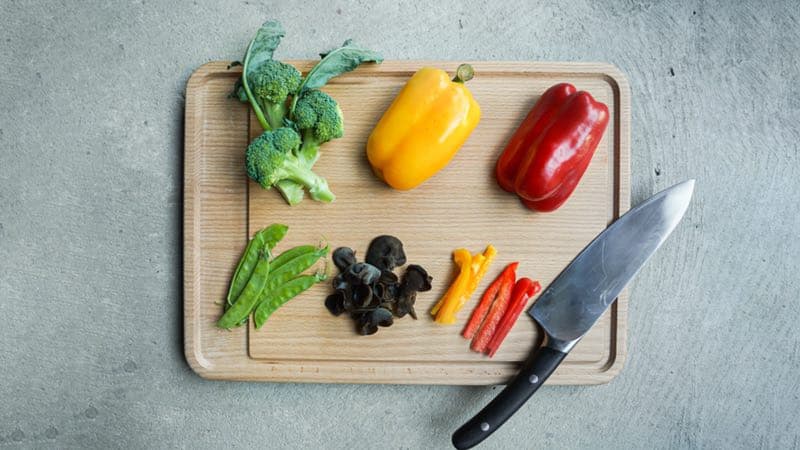 skärbräda ovanifrån med grönsaker och kniv