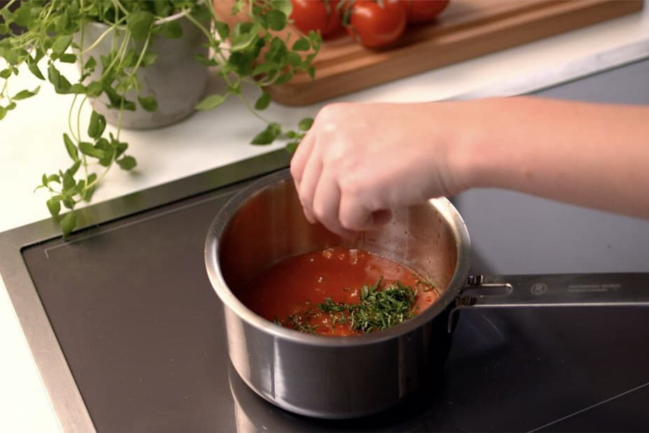 Kastrull med tomatsås och hackad persilja
