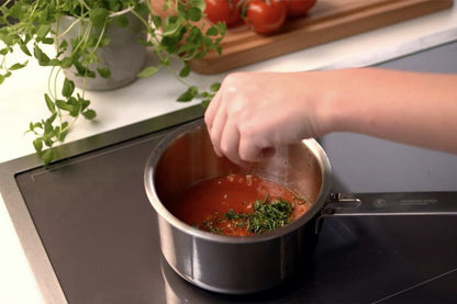 Kastrull med tomatsås och hackad persilja